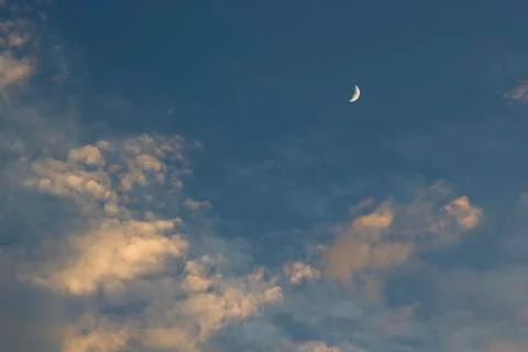Moon on dramatic sunset sky with clouds Stock Photos