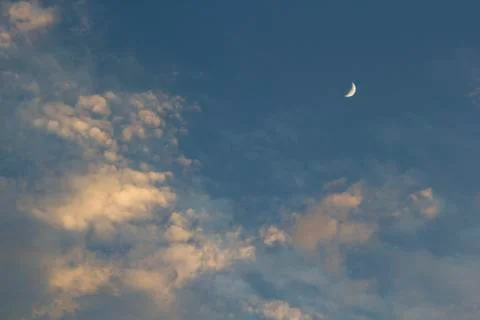 Moon on dramatic sunset sky with clouds Stock Photos