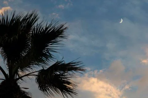 Moon on dramatic sunset sky with clouds Stock Photos