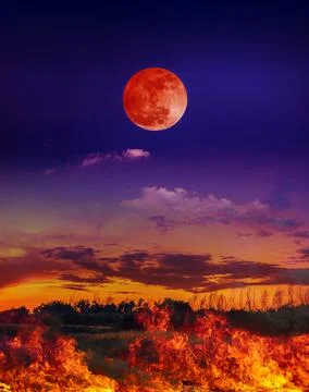 Moon eclipse. Night sky with blood moon above the fire is burning the meadow. Stock Photos