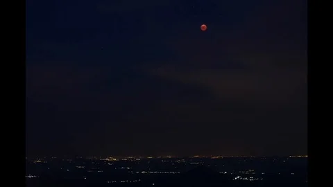 Moon eclipse over darken countryside moving on the sky Stock Footage 106354474