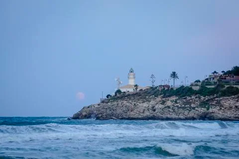 Moon eclipse over a lighthouse Stock Photos