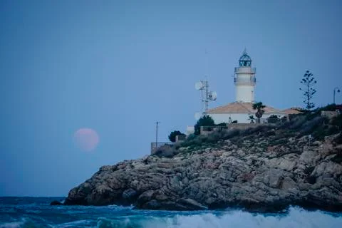 Moon eclipse over a lighthouse Stock Photos