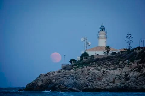 Moon eclipse over a lighthouse Stock Photos