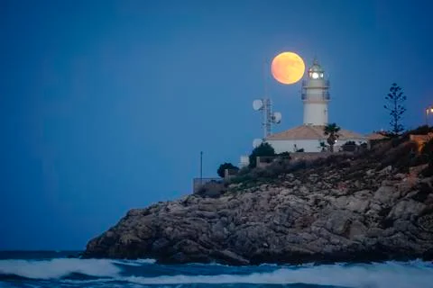 Moon eclipse over a lighthouse Stock Photos