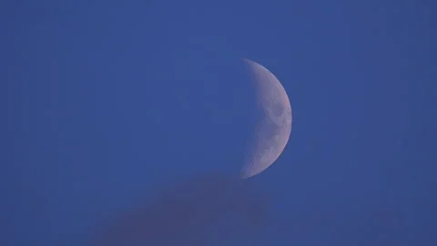 Moon Emerging from Behind Cloud on Blue Sky Background. Stock Footage 342261768