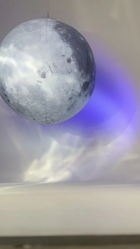 Moon globe hanging in studio with purple lighting effect. Decorative model of Stock Footage 339432998
