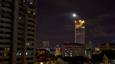 Moon going down behind a building in Kuala Lumpur, Malaysia Stock Footage 11128644