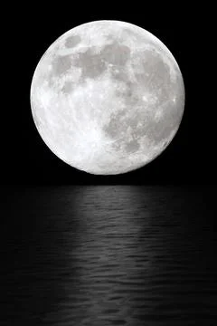 Moon at night in the black sky. The reflection of moonlight in the water Stock Photos