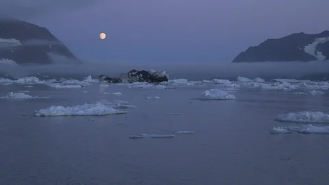 Moon over the Arctic Mountains and the ocean, Greenland Video stock 103576177