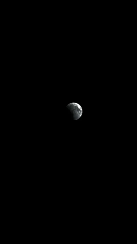 The moon partially covered by Earth's shadow during Luna eclipse Stock Footage 344828498