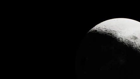 Moon is partially illuminated in the night sky during a clear evening Stock Footage 345054714