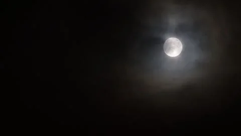 The moon plays hide and seek with the clouds at night Video stock 256756021