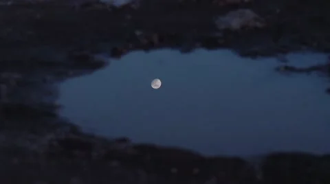 Moon reflecting in a puddle. Shot in slow motion Stock Footage 51113980