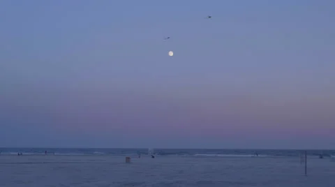Moon rises over beach sunset kites vacation Stock Footage 66541589