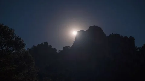 Moon rising over rock mountain time lapse Stock Footage 148606444