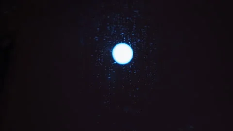 The moon shines bright through the door and shows the drip on the window on a Vidéo 331669235