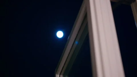The moon shines bright through the window on a cold dark night Stock Footage 331669151