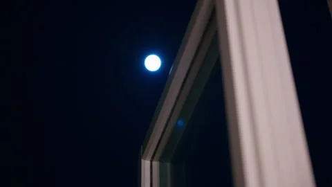 The moon shines bright through the window on a dark cold night Stock Footage 331669422