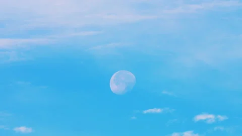 Moon shining in daytime blue sky with clouds Video stock 338129287