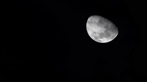 Moon in the sky with eerie clouds moving in front of it giving it an eerie Stock Footage 240010199