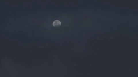 The moon slowly moving through a cloudy sky at night Stock Footage 247186782