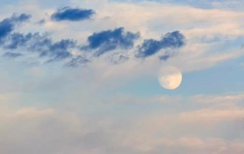 Moon surrounded by clouds at sunset Stock Photos