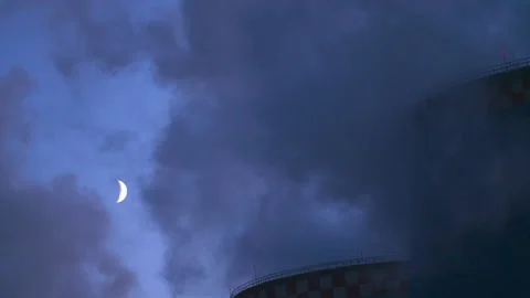 The moon through the smoke from the coal power plant. Stock Footage 99557060