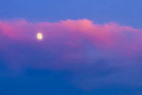 Moon under pink cloud on blue sky Foto stock