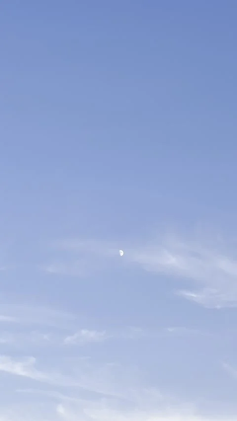 Moon Visible in Blue Sky Above Thin Clouds Stock Footage 345922911