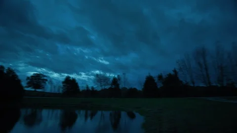 Moonlight Breaks Through Fast Moving Clouds at Night on a Farm Stock Footage 120341120