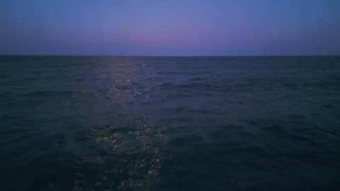 Moonlight reflecting on the calm ocean at night, creating a shimmering path Stock Footage 301699984