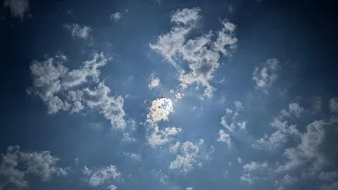 Moonlight shining through scattered clouds in night sky. Stock Photos