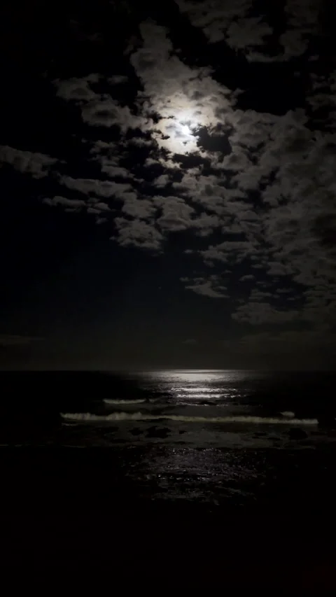 Moonlight from strawberry full moon reflected off ocean surface Stock Footage 344903687
