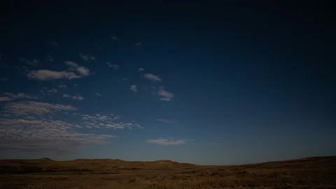 Moonlit clouds move quickly through a sky with stars in a time lapse  Stock Footage 209722472