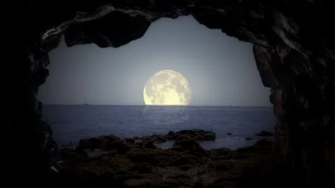 Moonlit Ocean View Through Cave Entrance With Rocky Shore and Calm Waters Stockbeeldmateriaal 318481250