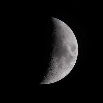Moon's curved face glows softly against the void Fotos Stock