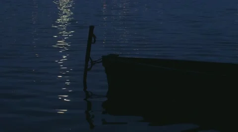 The moon's reflection in lake water and boat Stock Footage