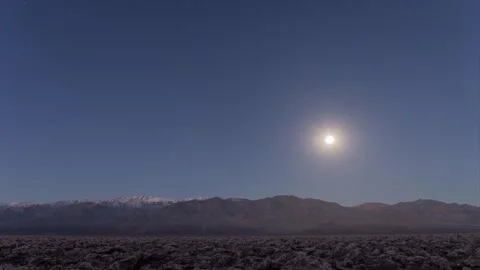 Moonset behind panamint mountains as sun rises over devils golfcourse in death Stock Footage 315875406