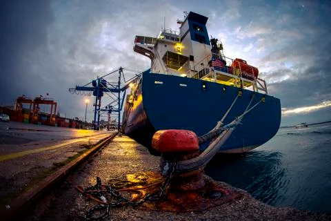 Moored big size container ship during twilight from a cloudy day with modern  Foto stock