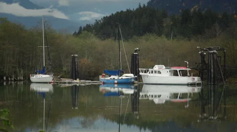 Moored boats floating and their reflections in crystal calm waters. Stock Footage 57515107