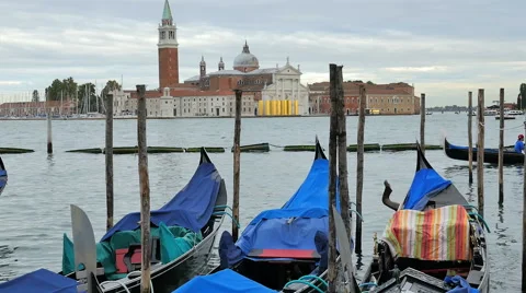 Moored Gondolas bob in the water as another gondola passes by-Venice, Italy Stock Footage 49013011