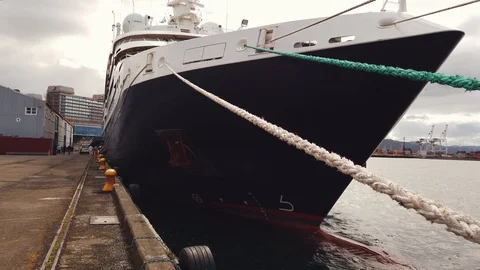 Mooring Lines attached to prow of vessel docked at old harbor on moody day Video stock 106694749