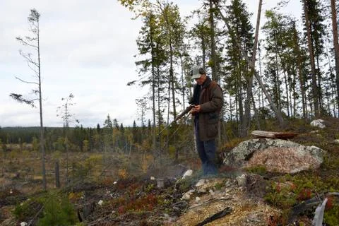 Moose hunter with a little fire using his smartphone Stock Photos