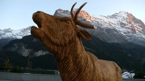 Moose statue, Cinema 4k pan view around a elk statuette, infront of eiger mou Stock Footage 87285249