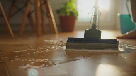 A mop is cleaning a wet tile floor in a home Stock Footage 288627444