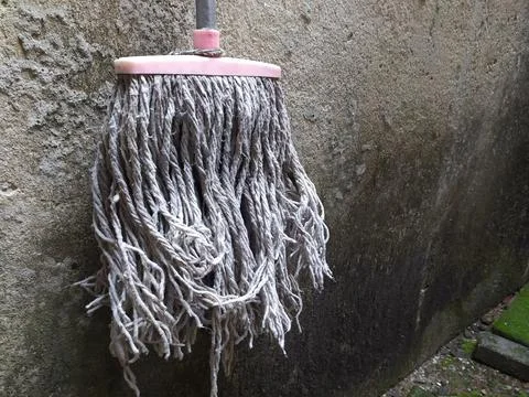 The mop is hanging up because it is no longer used Stock Photos