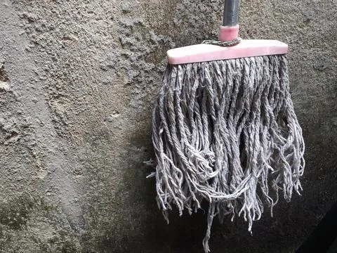 The mop is hanging up because it is no longer used Stock Photos