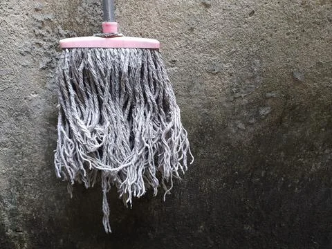The mop is hanging up because it is no longer used Stock Photos