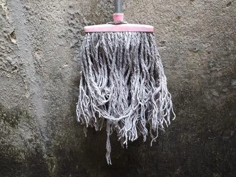 The mop is hanging up because it is no longer used Stock Photos